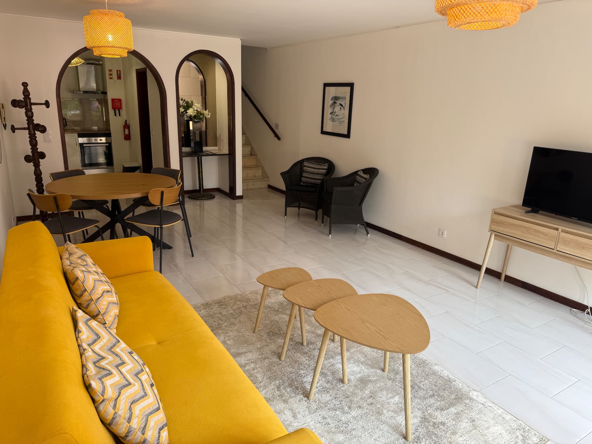 Low-angle view across the Comfort Villa living room towards the dining area and TV console